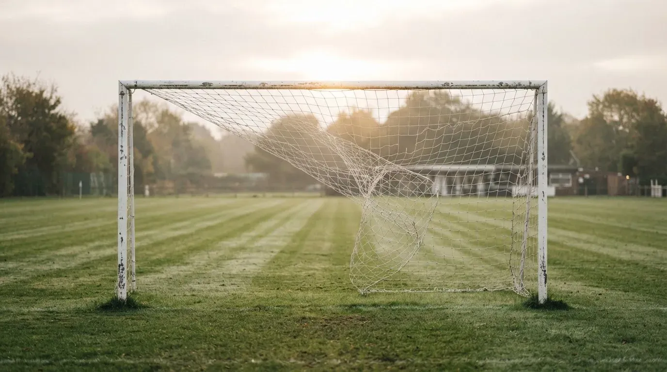 Ein Fussballtor mit locker hängendem Netz auf einem Trainingsplatz, das sich leicht im Wind bewegt.